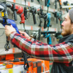 A,young,man,chooses,powerful,drill,in,the,hardware,store