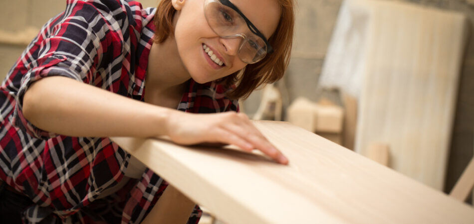 Female,joiner,holding,lumber,in,hands,,checking,quality,and,looking